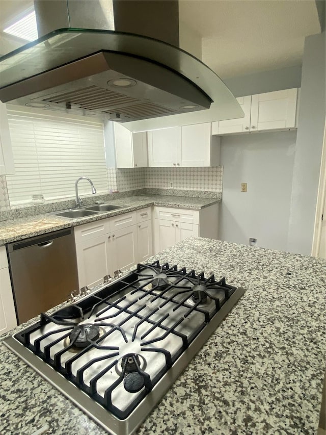 kitchen featuring white cabinets, dishwasher, backsplash, island exhaust hood, and a sink