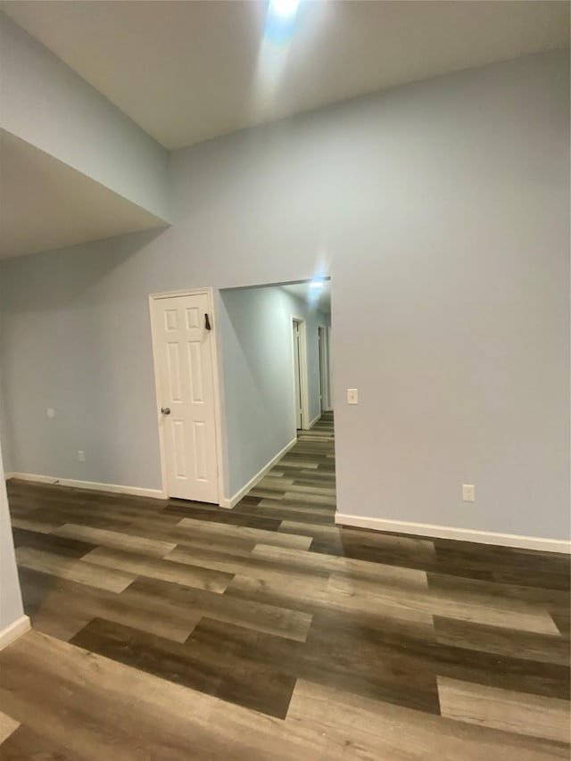 spare room featuring dark wood finished floors and baseboards