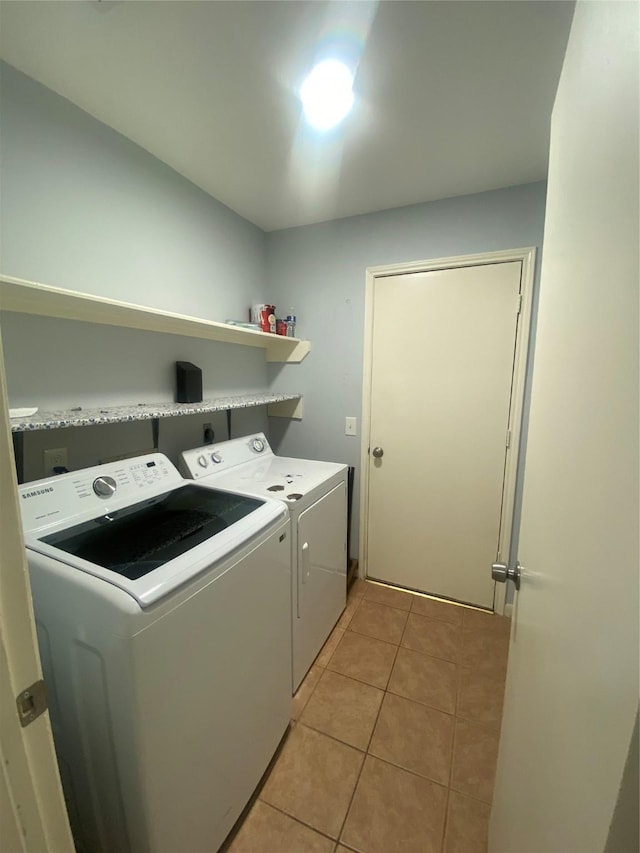 clothes washing area featuring laundry area, light tile patterned floors, and washer and dryer