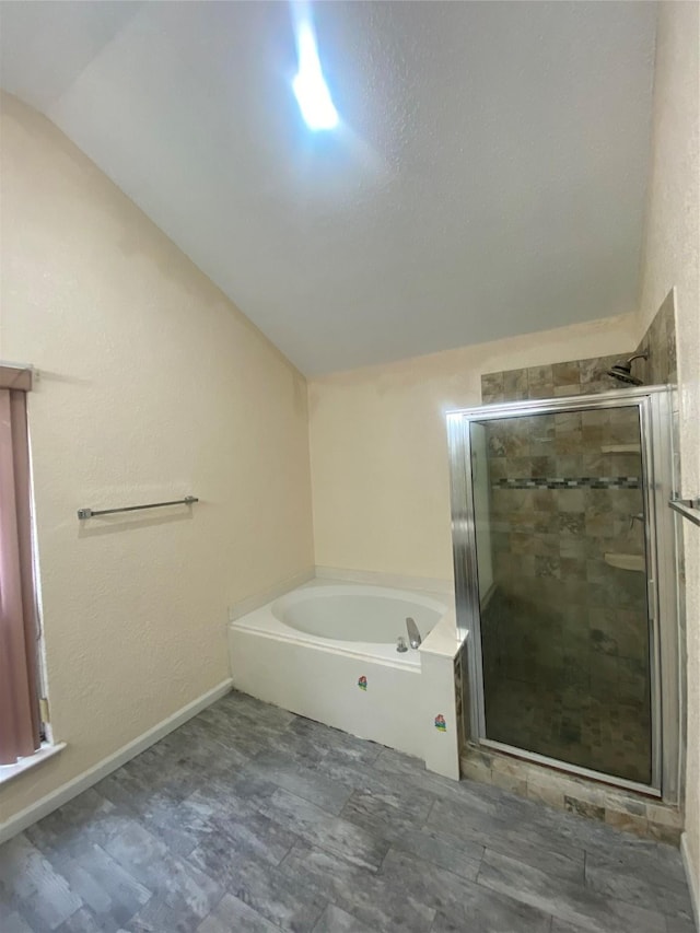 bathroom with lofted ceiling, a garden tub, and a shower stall