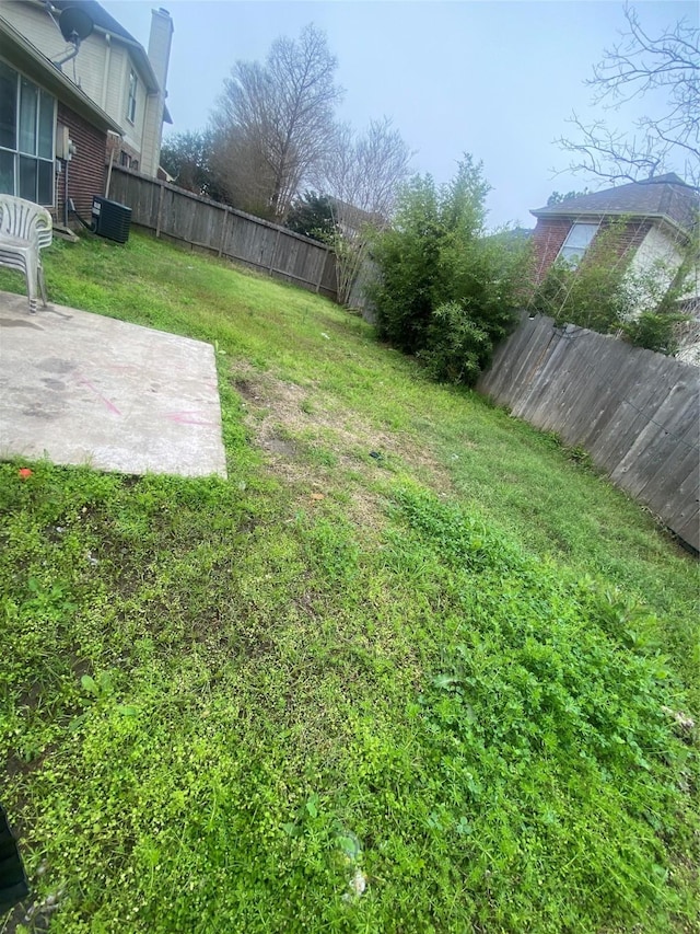 view of yard featuring central AC, a patio area, and a fenced backyard