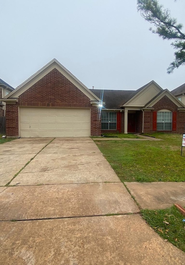 single story home with driveway, an attached garage, a front lawn, and brick siding