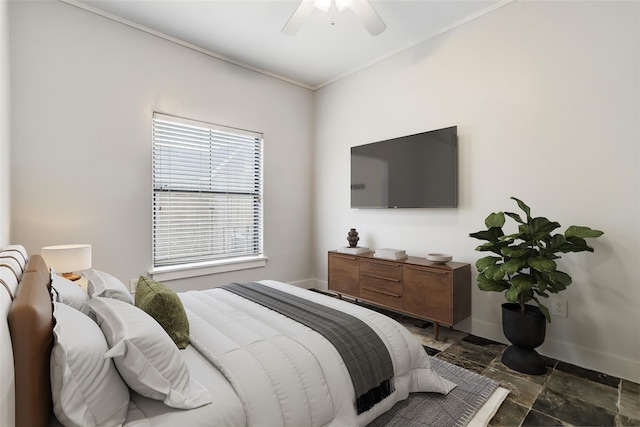 bedroom with stone finish floor, a ceiling fan, and baseboards