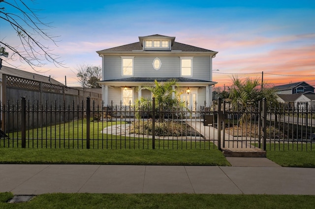 traditional style home with a fenced front yard, a front lawn, and a porch