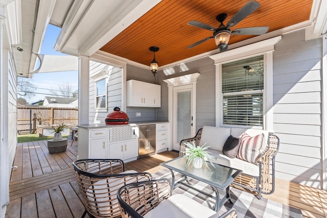 wooden deck featuring ceiling fan, fence, and an outdoor living space