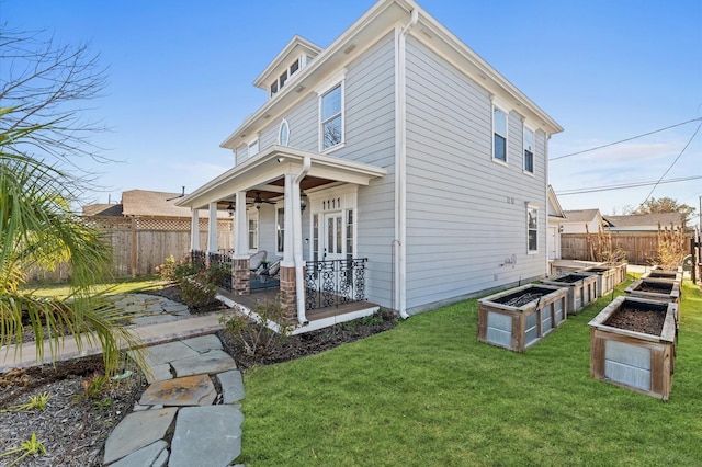 exterior space with fence private yard, ceiling fan, a vegetable garden, and a yard