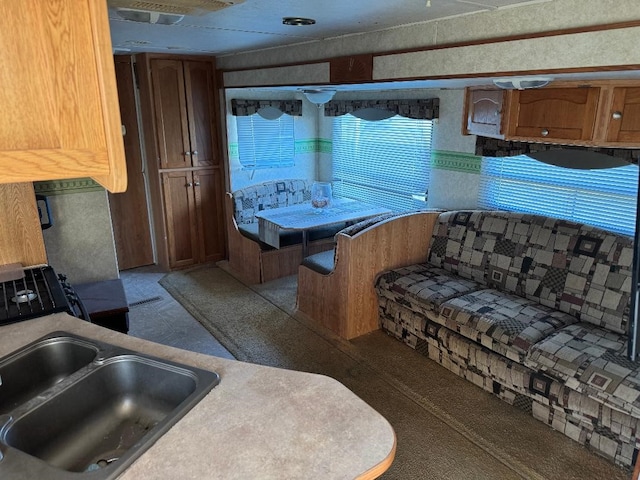 kitchen featuring brown cabinets, light countertops, and a sink