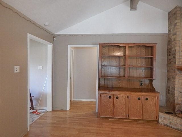 interior space featuring lofted ceiling with beams and light wood-type flooring