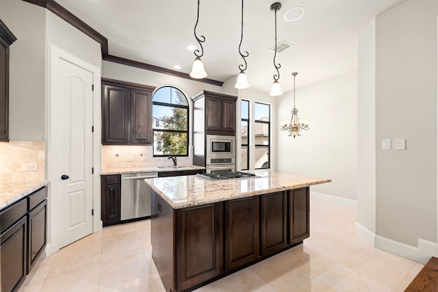 506 Knox St, Houston, TX 77007 - kitchen featuring stainless steel appliances, backsplash, dark brown cabinetry, a kitchen island, and light stone countertops