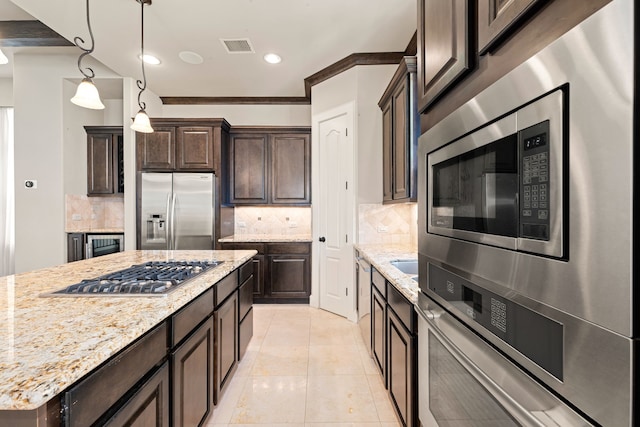 kitchen featuring stainless steel appliances, dark brown cabinets, and backsplash