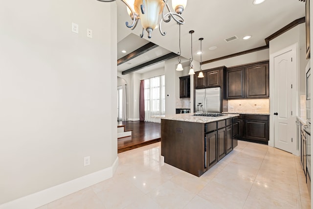 kitchen featuring baseboards, appliances with stainless steel finishes, a center island, an inviting chandelier, and backsplash