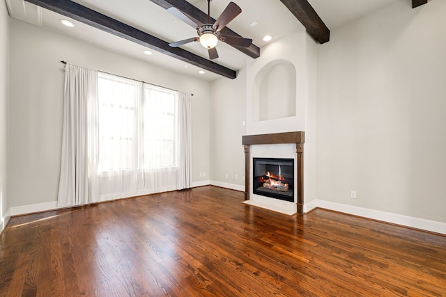 unfurnished living room featuring a fireplace with flush hearth, beamed ceiling, baseboards, and wood finished floors