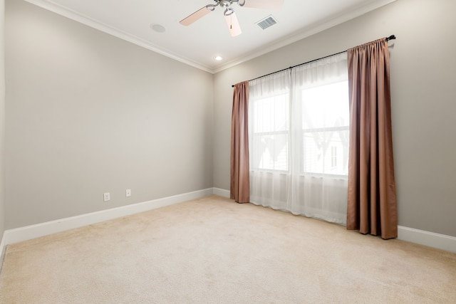 unfurnished room featuring light carpet, baseboards, visible vents, a ceiling fan, and ornamental molding