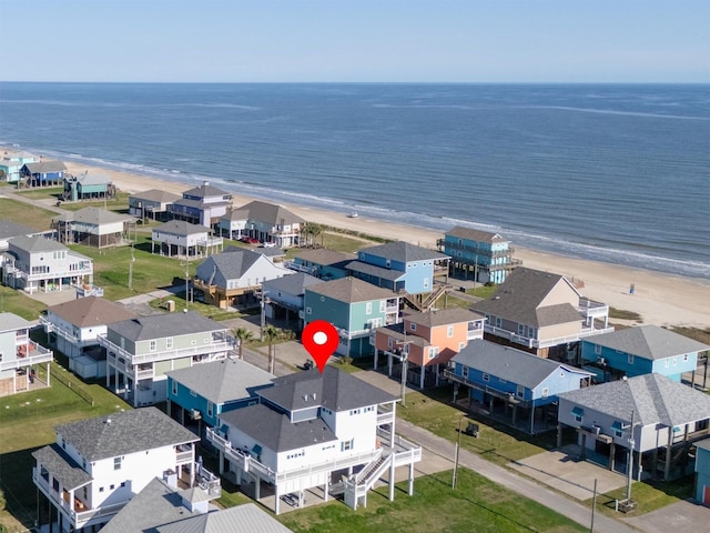 drone / aerial view featuring a beach view, a residential view, and a water view