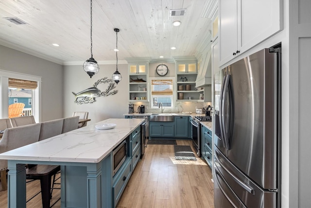 kitchen with visible vents, open shelves, stainless steel appliances, a kitchen bar, and a center island