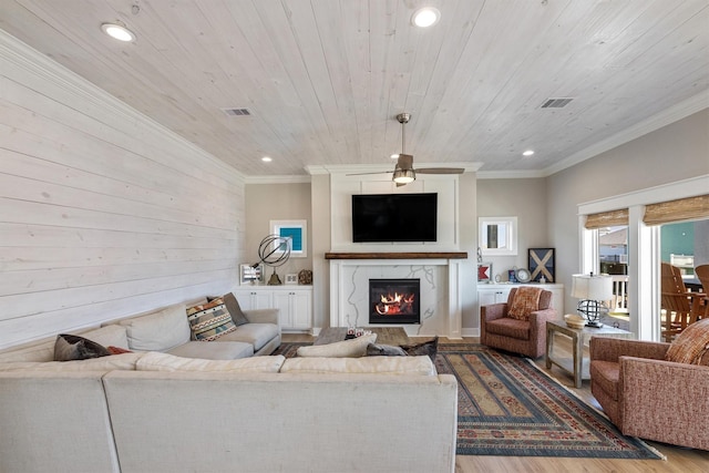 living area featuring visible vents, wood ceiling, wood finished floors, and crown molding