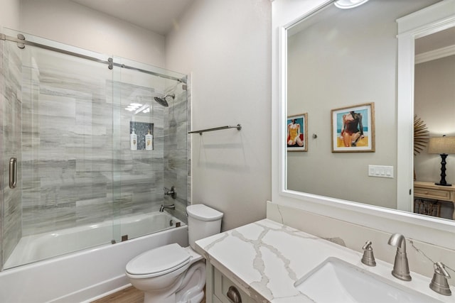 full bathroom with enclosed tub / shower combo, toilet, and vanity