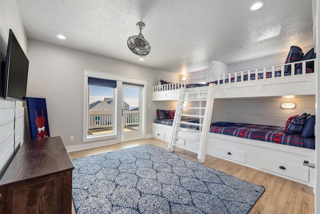 bedroom with baseboards, light wood finished floors, recessed lighting, access to exterior, and a textured ceiling