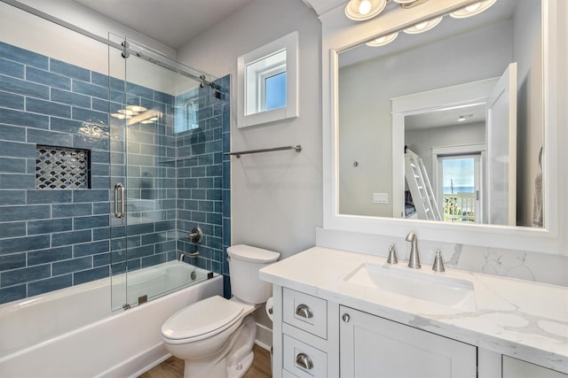 full bath with bath / shower combo with glass door, toilet, and vanity