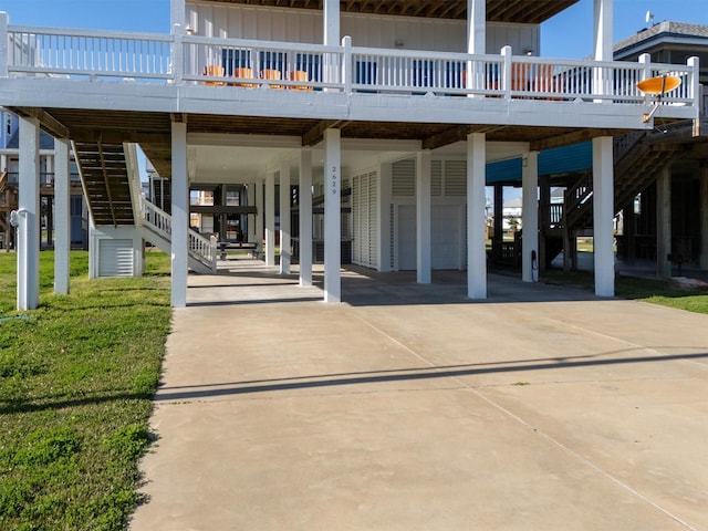 view of patio / terrace with stairway, a carport, and concrete driveway