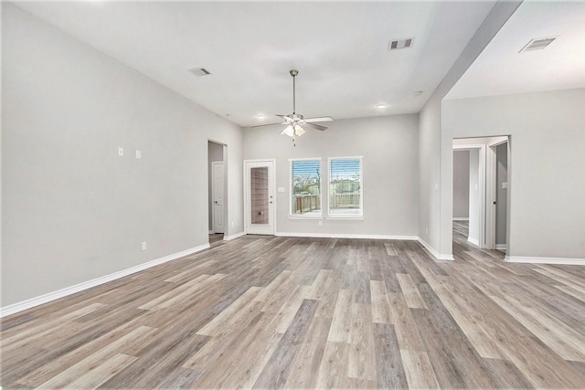 unfurnished room with ceiling fan, visible vents, light wood-style flooring, and baseboards