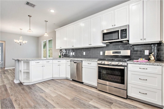 kitchen featuring open shelves, stainless steel appliances, visible vents, white cabinetry, and a peninsula