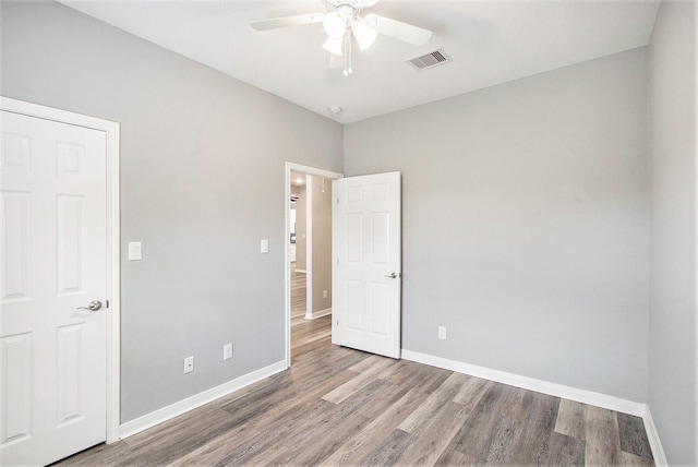 interior space featuring ceiling fan, light wood-style flooring, visible vents, and baseboards