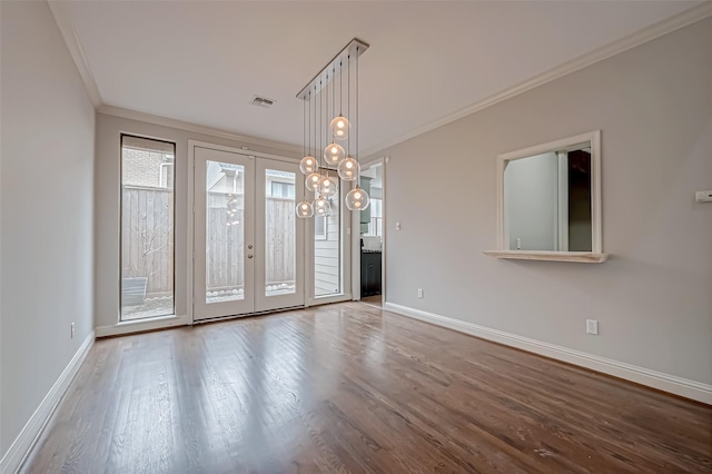 empty room featuring wood finished floors, visible vents, baseboards, french doors, and crown molding