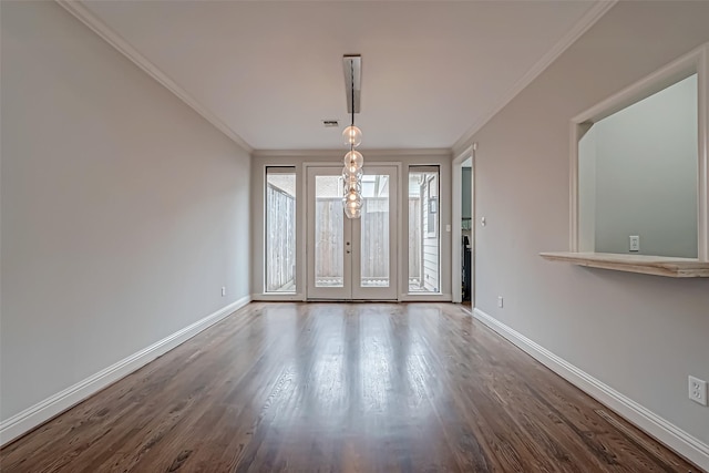 unfurnished room featuring ornamental molding, wood finished floors, and baseboards