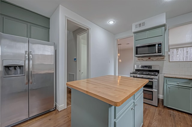 kitchen featuring stainless steel appliances, butcher block counters, visible vents, light wood-style flooring, and a kitchen island