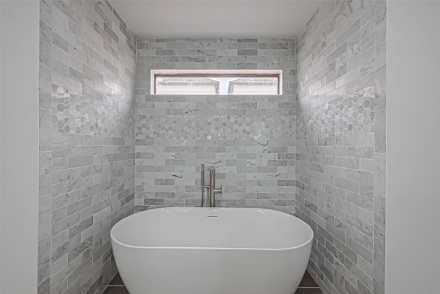 full bath featuring tile walls and a freestanding bath