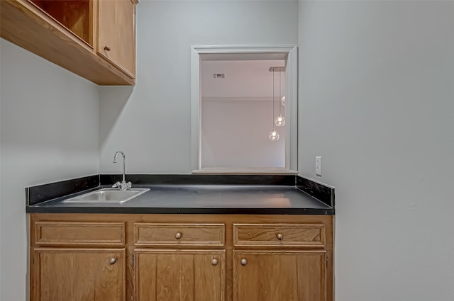 kitchen featuring dark countertops, a sink, and brown cabinets