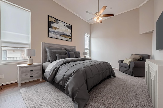 bedroom featuring lofted ceiling, light wood-style floors, baseboards, and crown molding