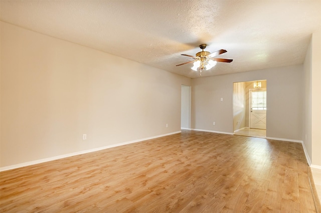 unfurnished room featuring light wood finished floors, a textured ceiling, baseboards, and a ceiling fan