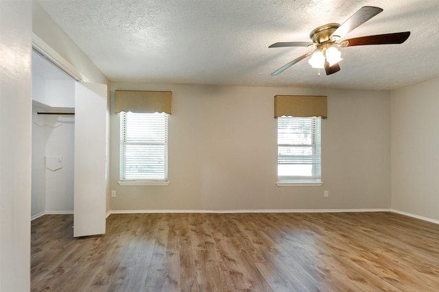 unfurnished bedroom featuring a textured ceiling, light wood-style flooring, and a ceiling fan