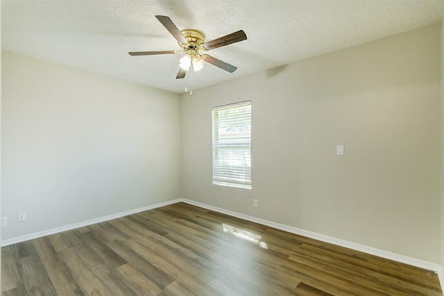 spare room with dark wood-style flooring, ceiling fan, a textured ceiling, and baseboards