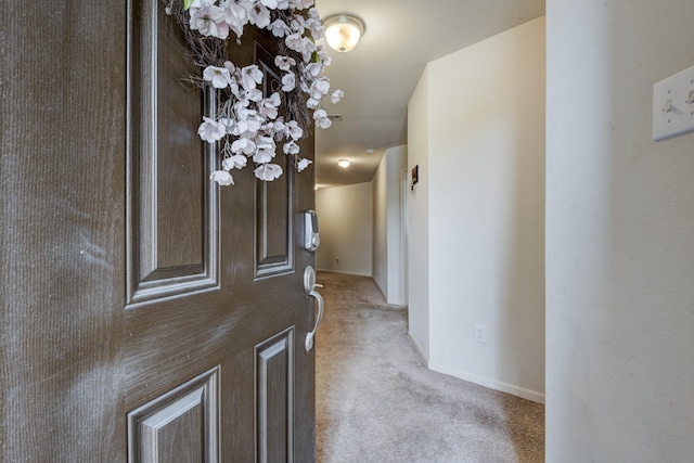 hall featuring light carpet and baseboards