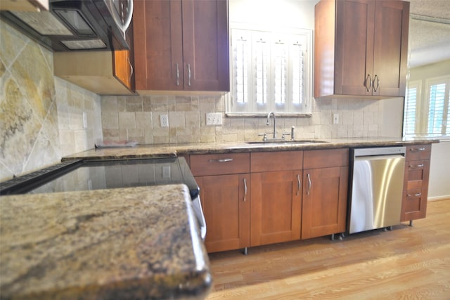 kitchen with decorative backsplash, a sink, light wood-type flooring, exhaust hood, and dishwasher