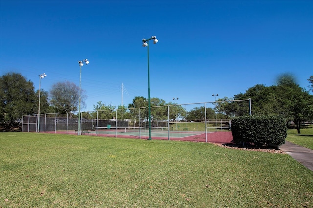 view of sport court with fence and a yard