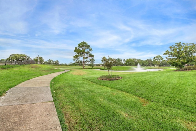 view of home's community with a lawn and a water view