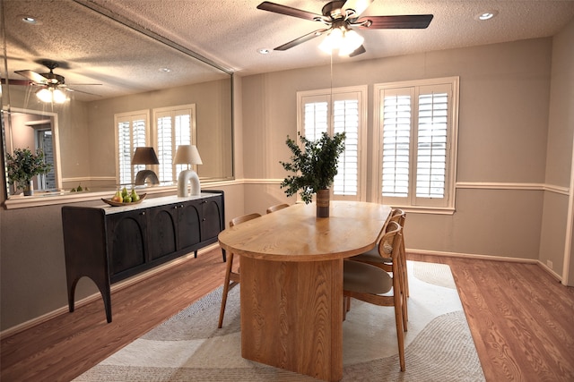 dining room with a wealth of natural light, wood finished floors, a ceiling fan, and a textured ceiling