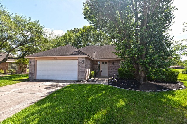 ranch-style home with brick siding, a front yard, and an attached garage