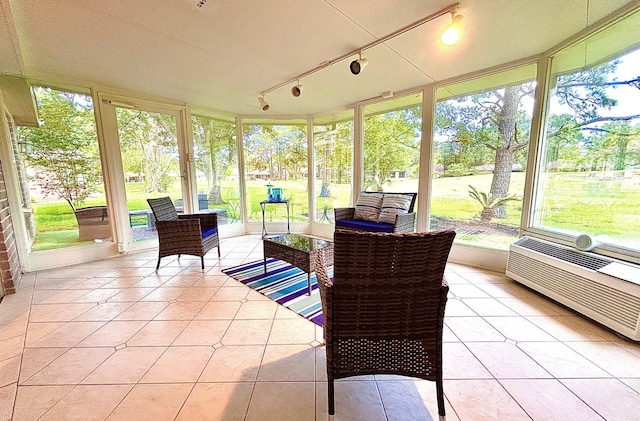 sunroom / solarium featuring track lighting and a healthy amount of sunlight