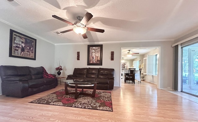 living room with wood finished floors, a ceiling fan, and visible vents