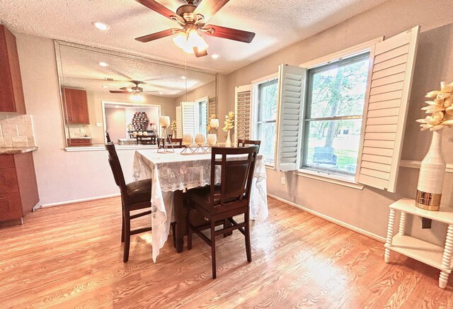 dining area with a textured ceiling, ceiling fan, baseboards, and light wood-type flooring