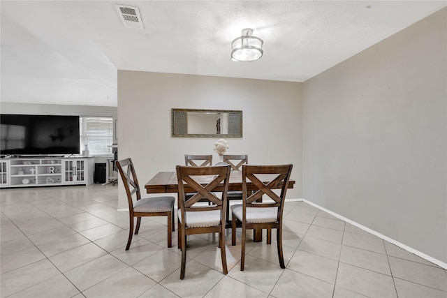 dining space with light tile patterned floors, baseboards, and visible vents