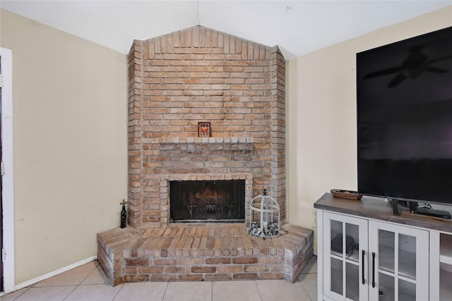 living room with light tile patterned floors, a fireplace, lofted ceiling, and baseboards