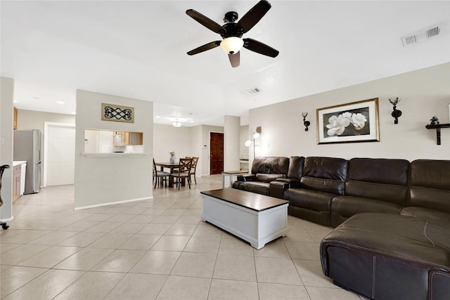 living room featuring a ceiling fan, visible vents, and light tile patterned floors