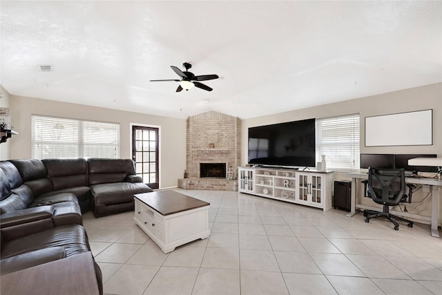 living room featuring light tile patterned floors, visible vents, ceiling fan, vaulted ceiling, and a fireplace