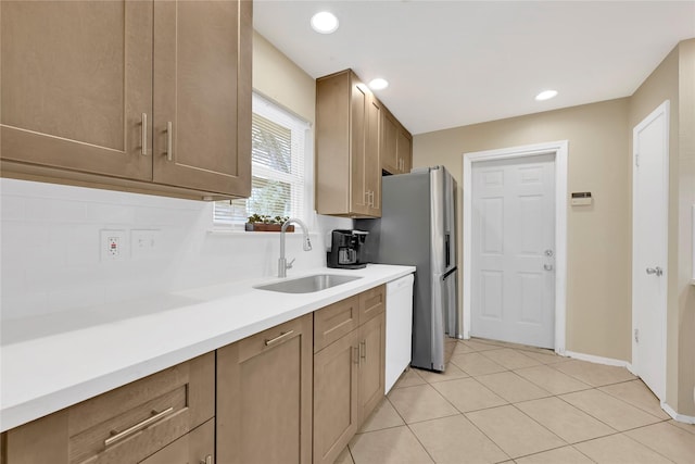 kitchen with light tile patterned floors, tasteful backsplash, dishwasher, light countertops, and a sink